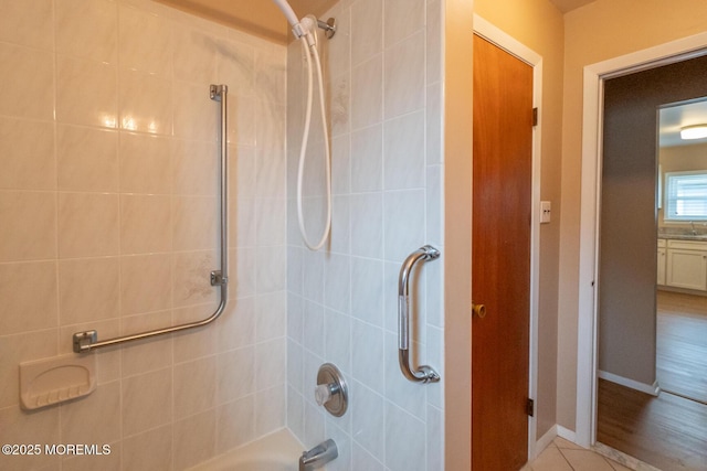 bathroom with tiled shower / bath and tile patterned flooring