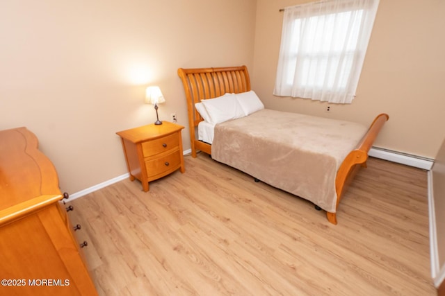 bedroom with a baseboard radiator and hardwood / wood-style floors