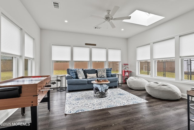 living area featuring a healthy amount of sunlight, visible vents, and wood finished floors