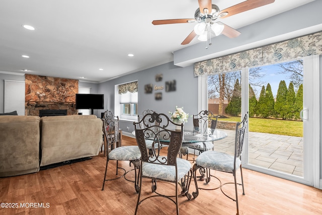 dining room featuring ornamental molding, recessed lighting, a fireplace, and wood finished floors