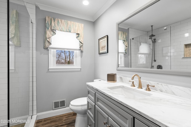 full bathroom featuring visible vents, a tile shower, crown molding, and wood finished floors