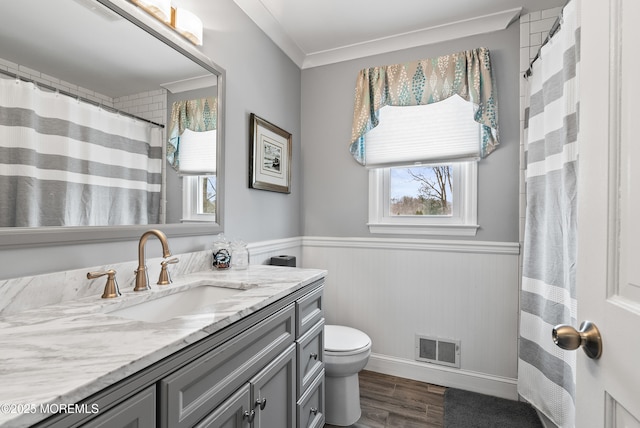 full bath with wainscoting, vanity, toilet, and wood finished floors