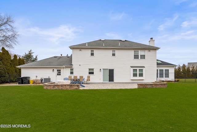 rear view of property with a yard, a chimney, central AC unit, a patio area, and fence