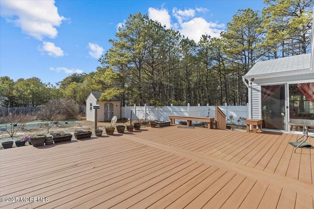 deck with an outdoor structure, a storage shed, and fence