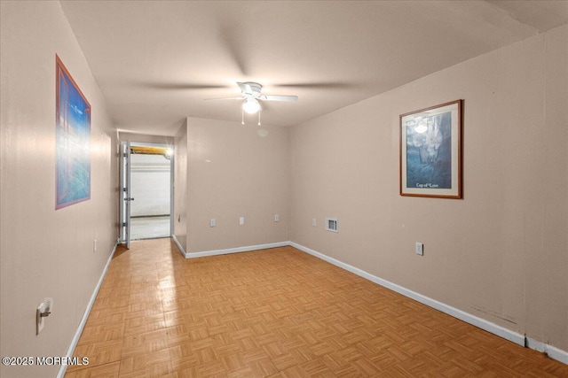 empty room featuring baseboards, visible vents, and a ceiling fan