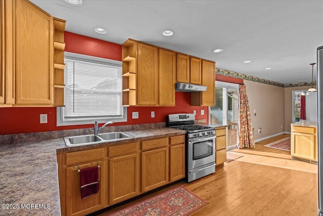 kitchen featuring open shelves, gas stove, a sink, light wood-type flooring, and under cabinet range hood