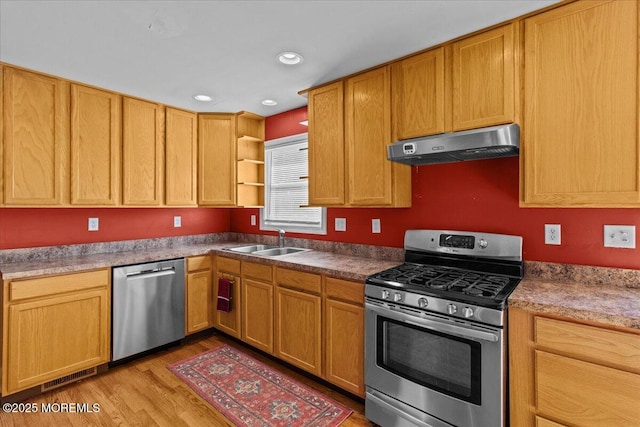 kitchen featuring light wood-style floors, stainless steel appliances, under cabinet range hood, open shelves, and a sink