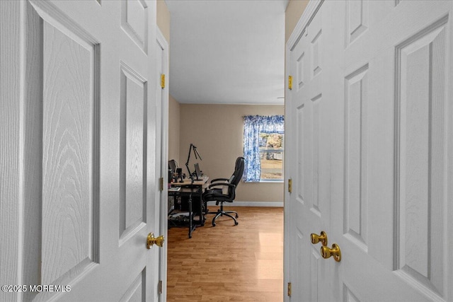 office area with light wood-style floors and baseboards