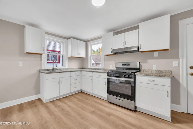 kitchen featuring white cabinetry, sink, stainless steel gas range oven, and light wood-type flooring