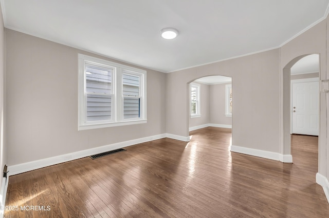 spare room with dark hardwood / wood-style flooring and ornamental molding