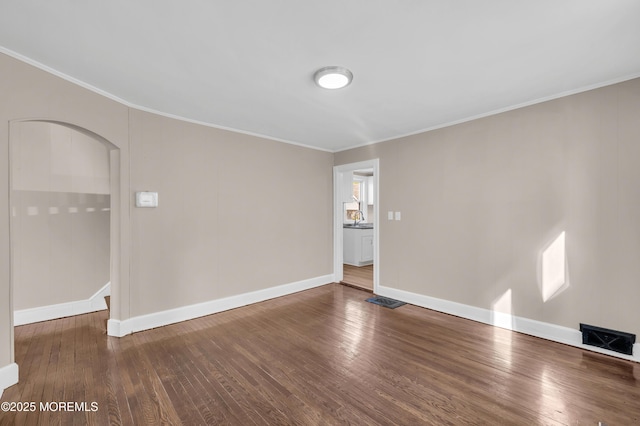 spare room featuring sink, hardwood / wood-style flooring, and ornamental molding