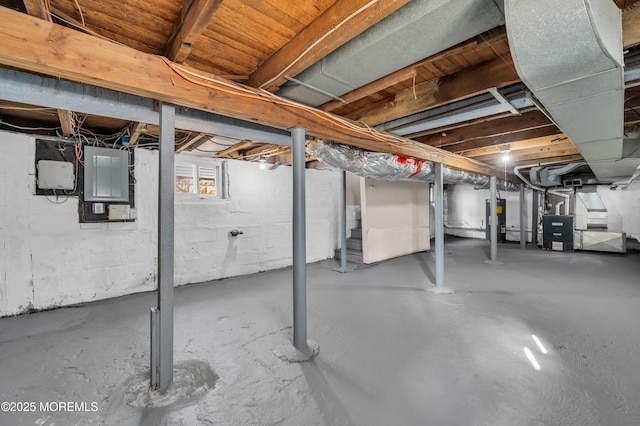 basement with heating unit, electric panel, and water heater