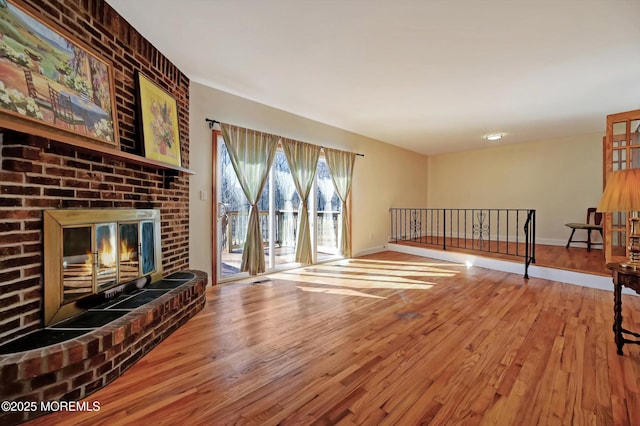 living room featuring hardwood / wood-style flooring and a brick fireplace