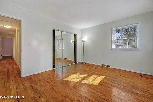 unfurnished bedroom featuring a closet and hardwood / wood-style floors