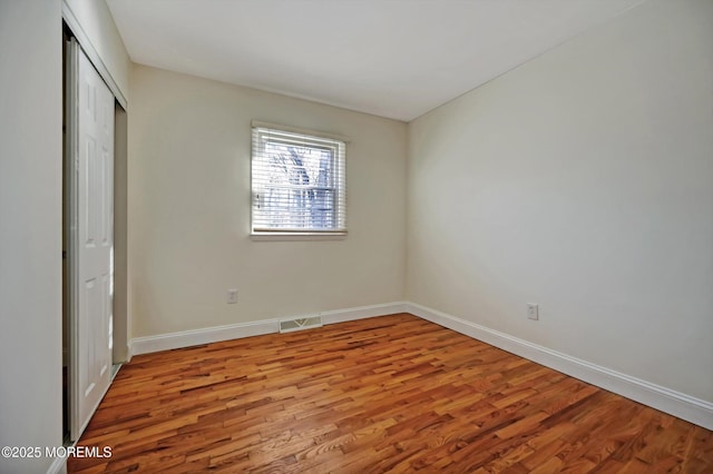 unfurnished bedroom featuring light wood-type flooring and a closet