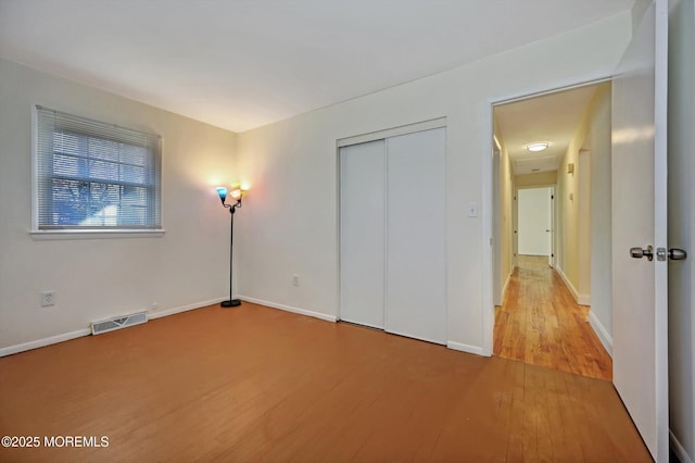 unfurnished bedroom with hardwood / wood-style floors and a closet