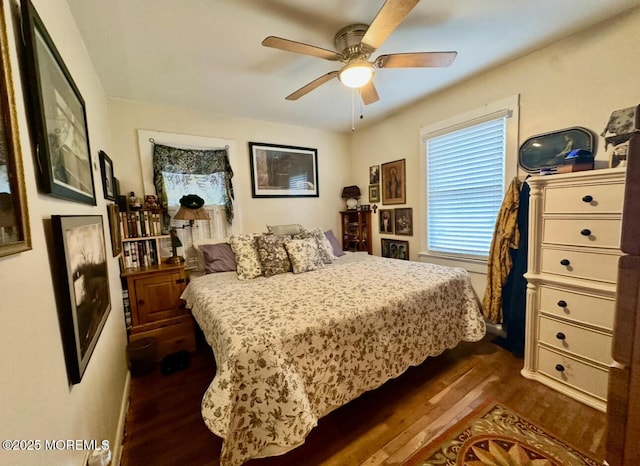 bedroom with dark hardwood / wood-style flooring and ceiling fan