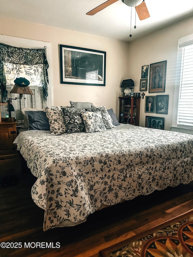 bedroom with dark hardwood / wood-style flooring and ceiling fan