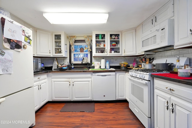 kitchen with white appliances, dark hardwood / wood-style flooring, white cabinets, and tasteful backsplash