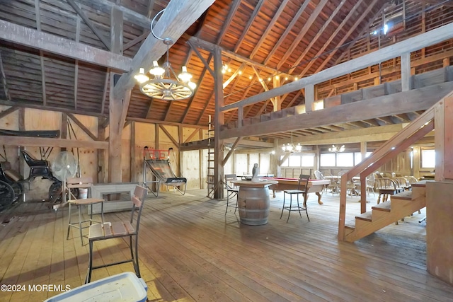 interior space featuring hardwood / wood-style flooring, high vaulted ceiling, and a notable chandelier