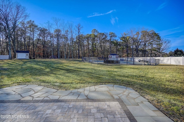 view of yard featuring a storage unit, a pool, and a patio area