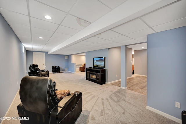 carpeted living room featuring a paneled ceiling