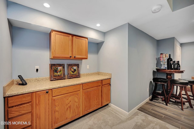 kitchen with light stone counters and light hardwood / wood-style flooring