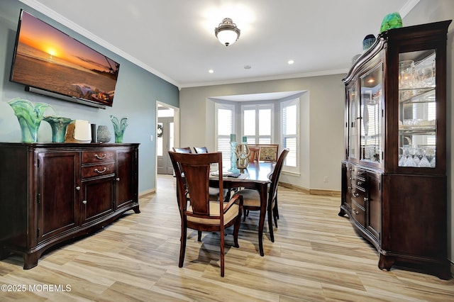 dining area with light hardwood / wood-style floors and ornamental molding