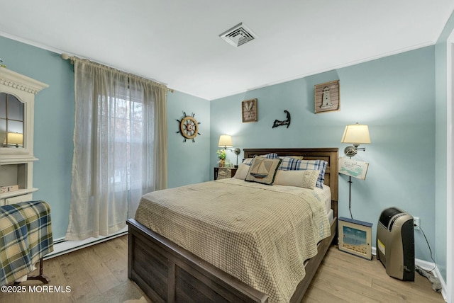 bedroom with light hardwood / wood-style flooring and crown molding