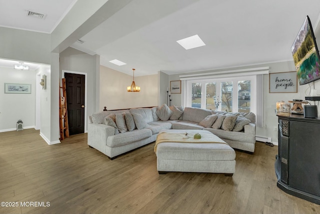 living room with a baseboard heating unit, hardwood / wood-style flooring, and a chandelier