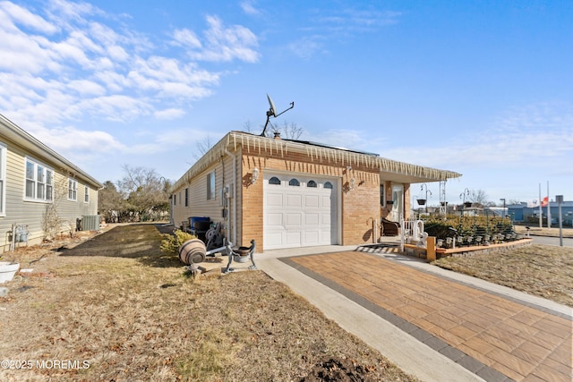 view of front of home with a garage and central AC unit