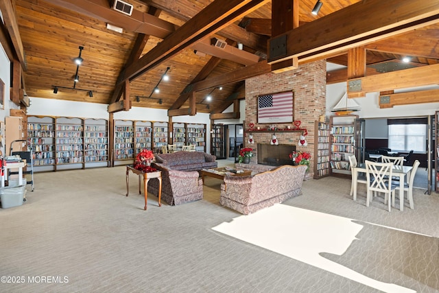 living room with wood ceiling, high vaulted ceiling, a brick fireplace, light colored carpet, and beamed ceiling