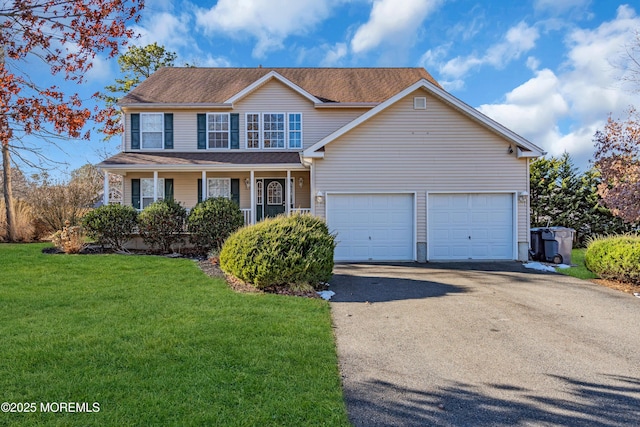 view of front of property featuring a porch, a garage, and a front lawn