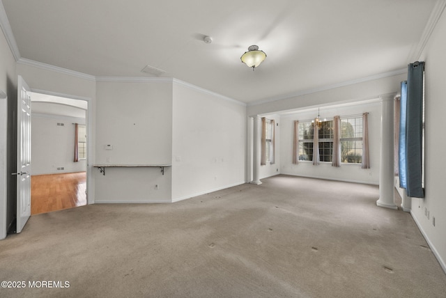unfurnished living room with light colored carpet, ornate columns, a notable chandelier, and ornamental molding
