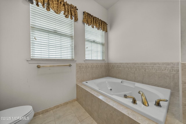 bathroom with a relaxing tiled tub, toilet, and tile patterned floors