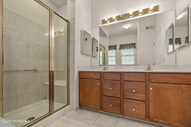 bathroom with a shower with shower door, tile patterned flooring, and vanity
