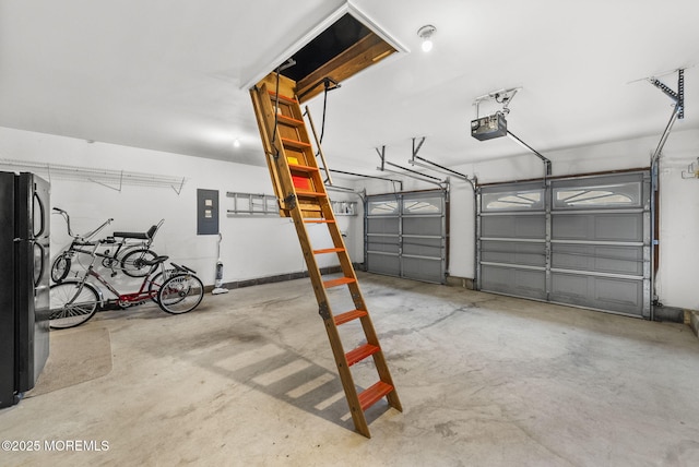garage with a garage door opener, black refrigerator, and electric panel