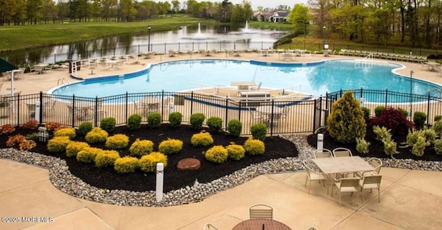 view of pool featuring a patio and a water view