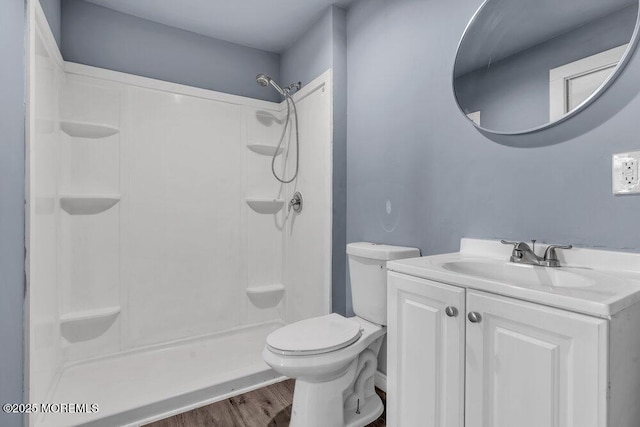 bathroom featuring a shower, vanity, toilet, and hardwood / wood-style floors