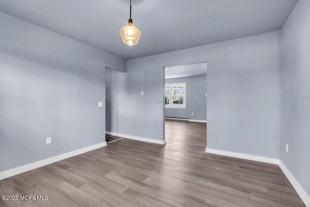 spare room with hardwood / wood-style flooring and a baseboard heating unit