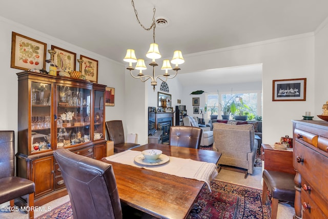 dining room featuring a chandelier, visible vents, and ornamental molding