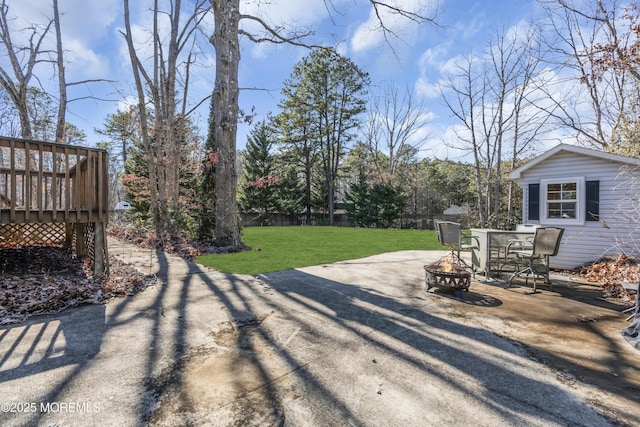 view of yard with a deck, an outdoor fire pit, a patio area, and fence