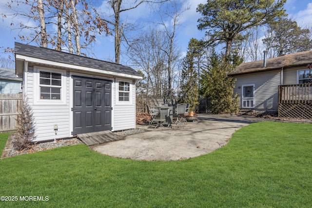 view of outdoor structure featuring an outdoor fire pit, fence, and an outdoor structure