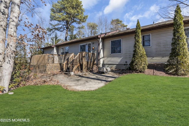 back of property with crawl space, a patio area, a lawn, and a wooden deck