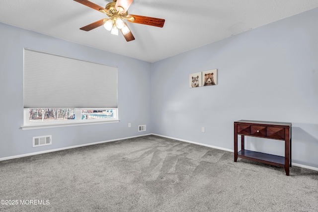 carpeted spare room with ceiling fan