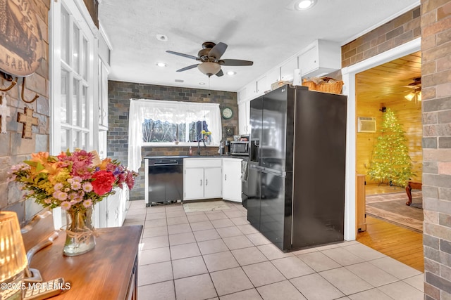 kitchen featuring dark countertops, black appliances, white cabinets, and light tile patterned flooring