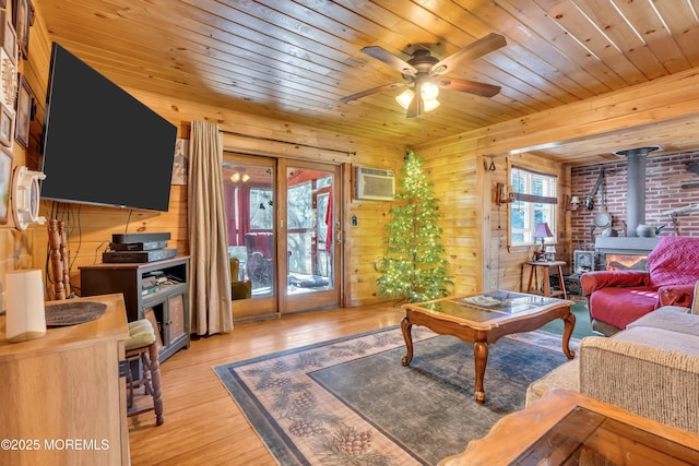 living room featuring a wood stove, light wood-type flooring, wood ceiling, and an AC wall unit