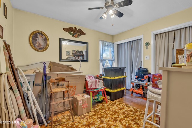 game room with wood finished floors and a ceiling fan