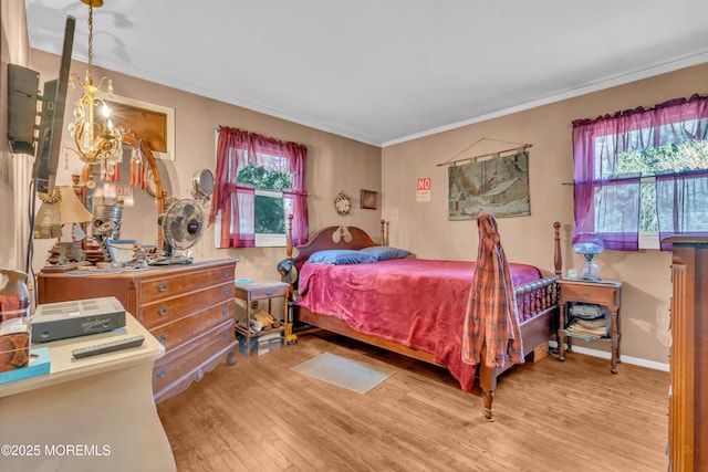 bedroom with baseboards, multiple windows, ornamental molding, and wood finished floors