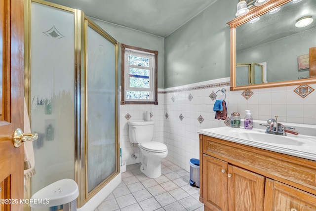 bathroom featuring toilet, a shower stall, vanity, and tile patterned floors